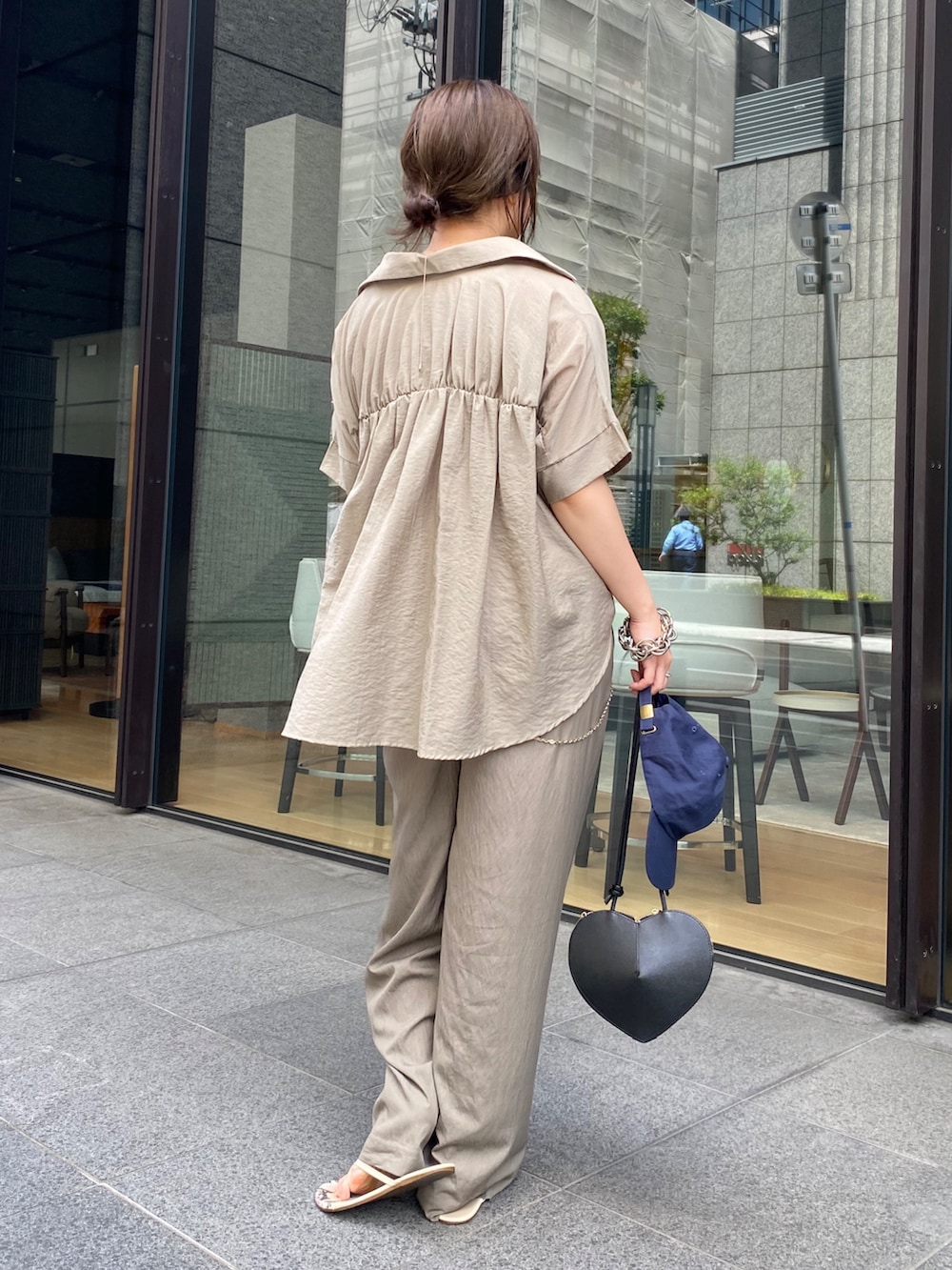 ベージュ系のシャツ/ブラウス、ブラック系のショルダーバッグ、ベージュ系のTシャツ/カットソーを着用したレディースの夏コーディネートの9枚目の写真