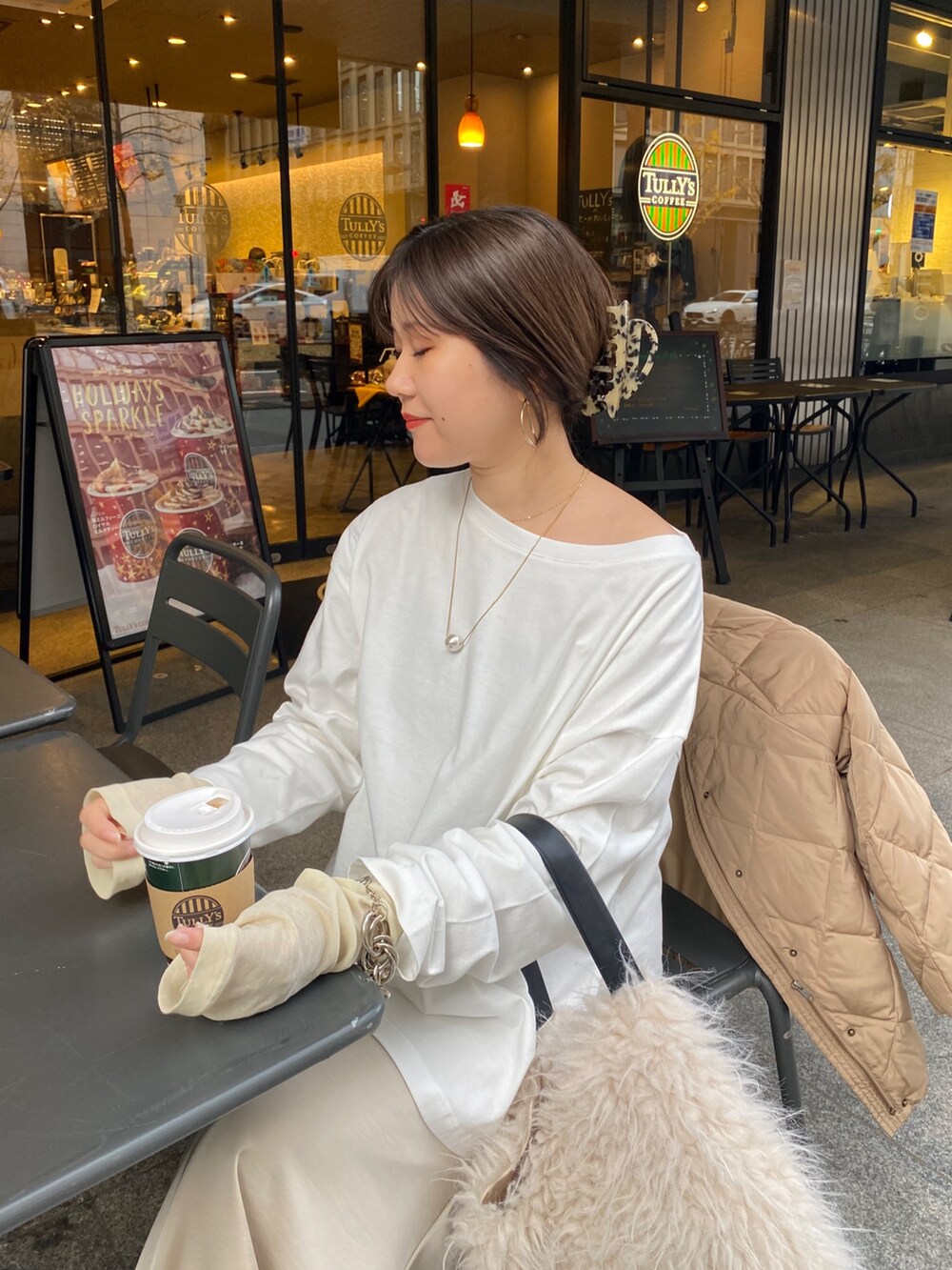 ホワイト系のTシャツ/カットソー、ベージュ系のスカート、イエロー系のTシャツ/カットソーを着用したレディースの冬コーディネートの2枚目の写真
