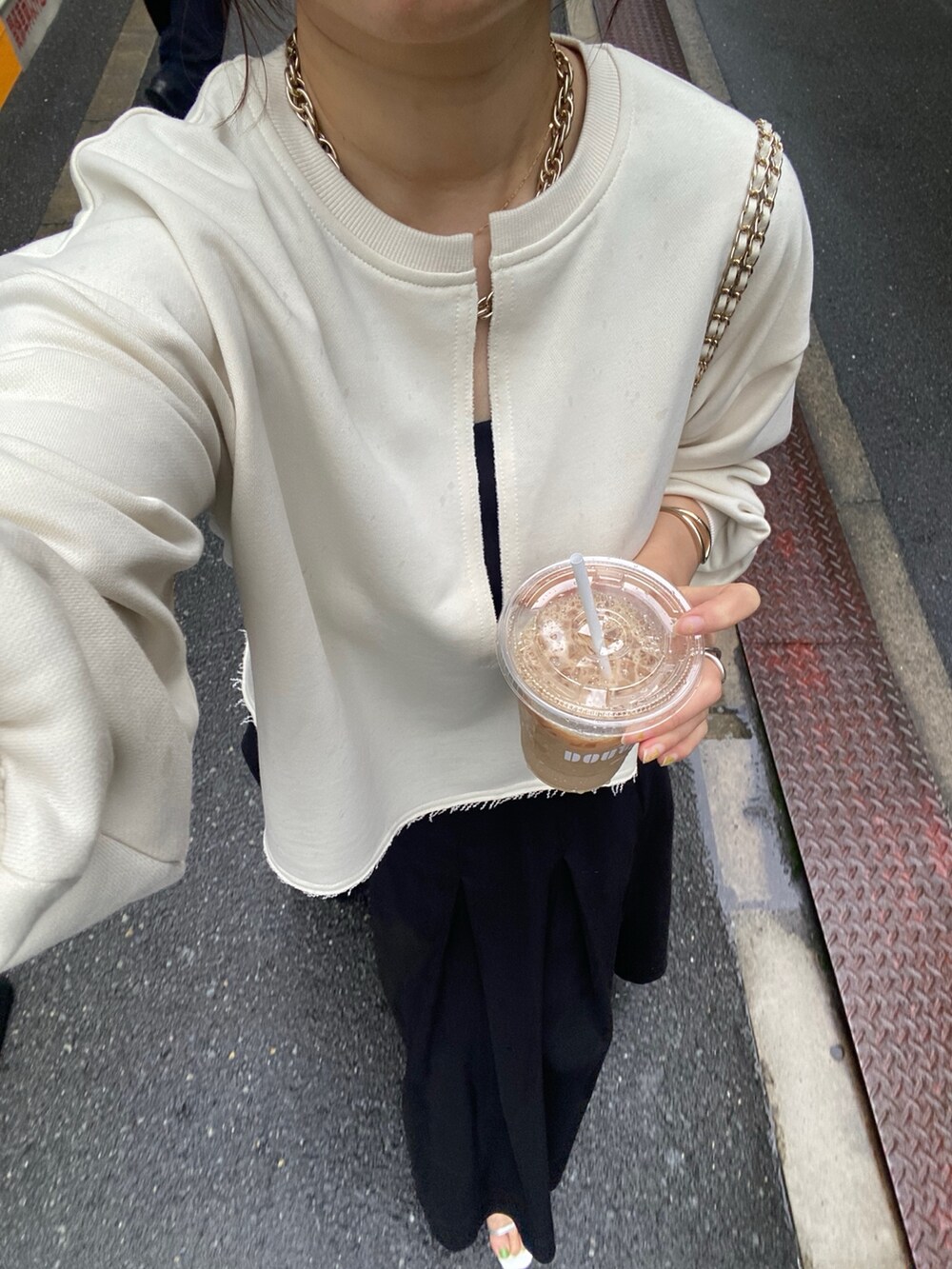 ベージュ系のスウェット、ブラック系のスカート、ホワイト系のショルダーバッグを着用したレディースの冬コーディネートの3枚目の写真