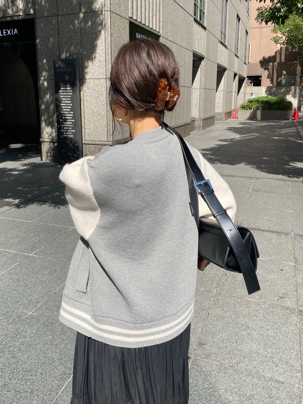 グレー系のその他アウター、ブラック系のワンピース、ブラック系のブーツを着用したレディースの秋コーディネートの6枚目の写真