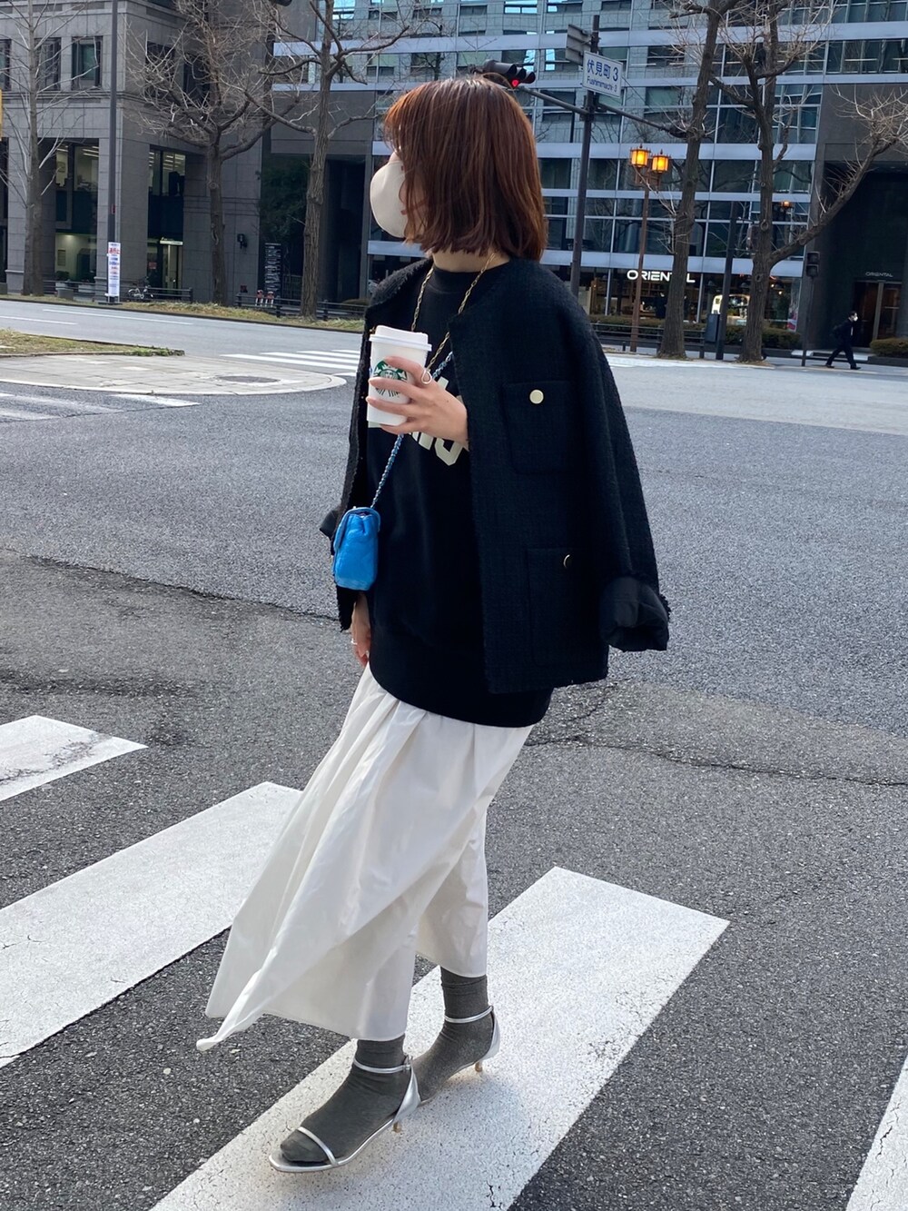 ブラック系のスウェット、ブラック系のノーカラージャケット、ホワイト系のスカートを着用したレディースの春コーディネートの6枚目の写真