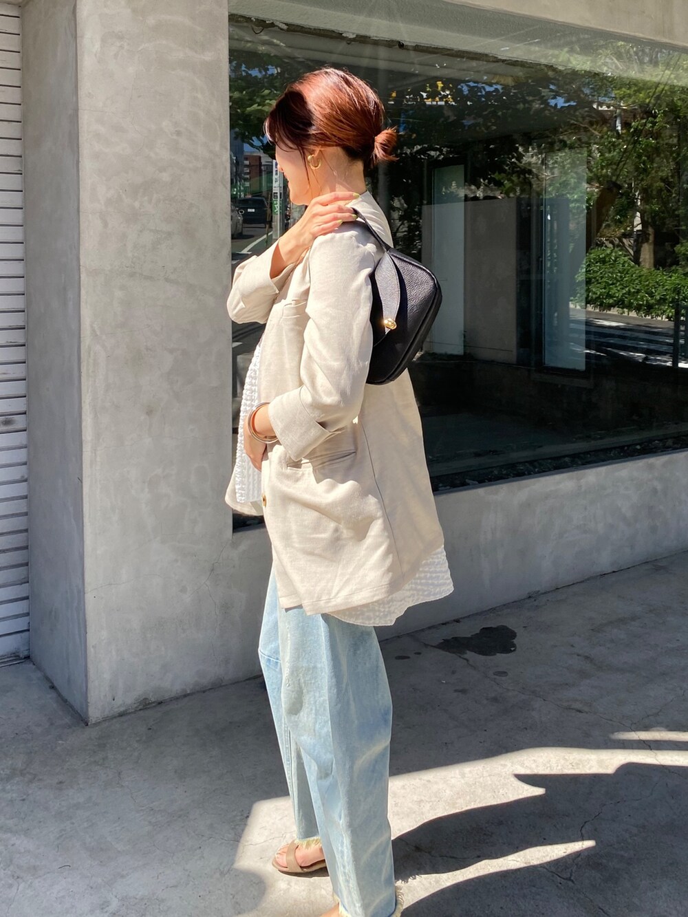 ホワイト系のキャミソール、ブルー系のデニムパンツ、ブラック系のショルダーバッグを着用したレディースの夏コーディネートの7枚目の写真