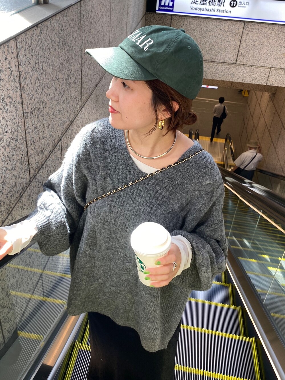 グレー系のニット/セーター、ブラック系のスカートを着用したレディースの秋コーディネートの9枚目の写真