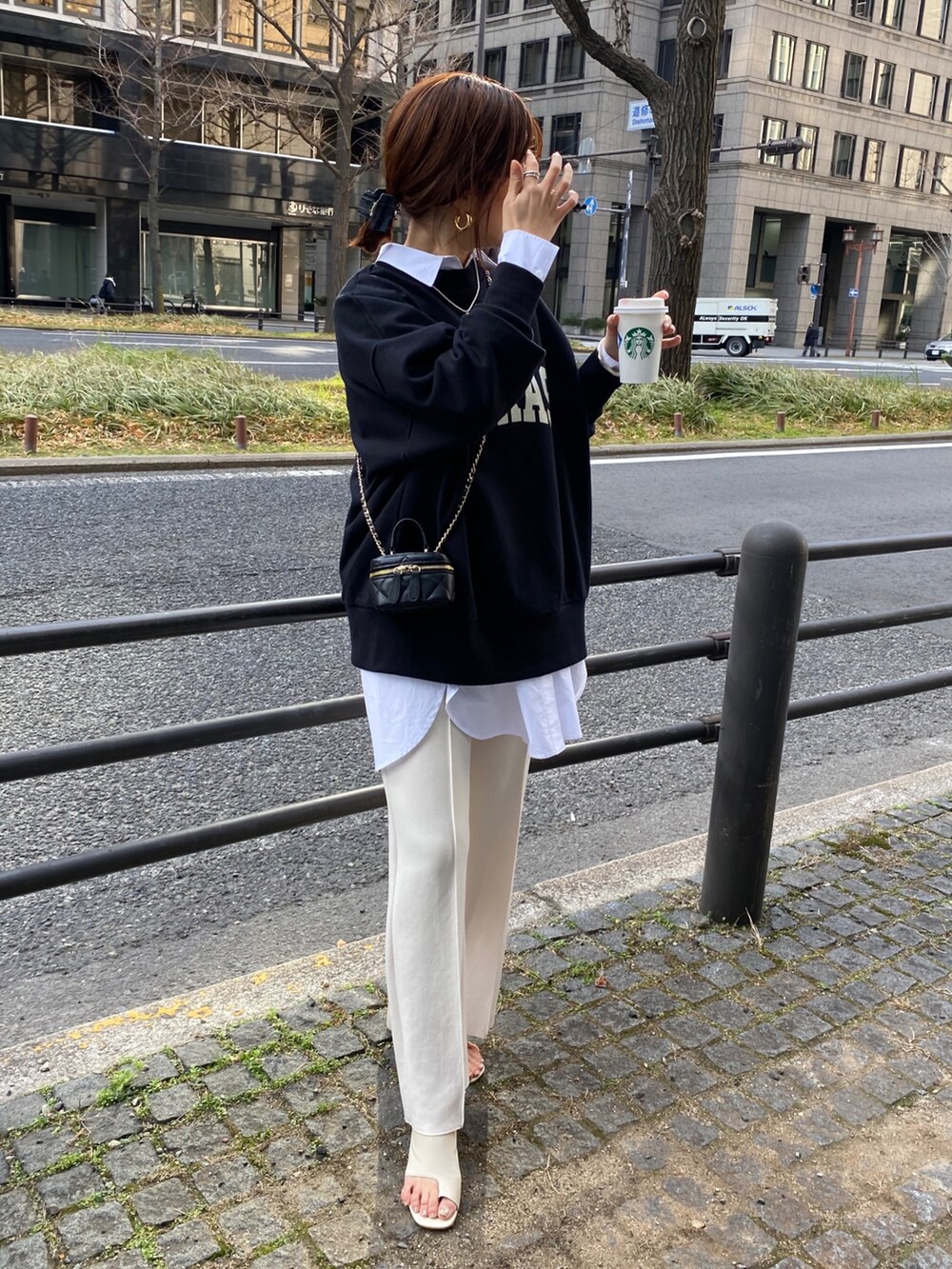 ブラック系のスウェット、ホワイト系のシャツ/ブラウス、ホワイト系のスラックスを着用したレディースの春コーディネートの5枚目の写真