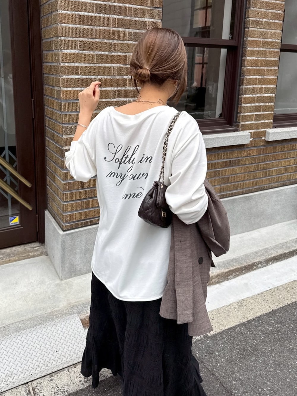 ホワイト系のTシャツ/カットソー、ブラック系のスカート、ブラウン系のテーラードジャケットを着用したレディースの冬コーディネートの7枚目の写真