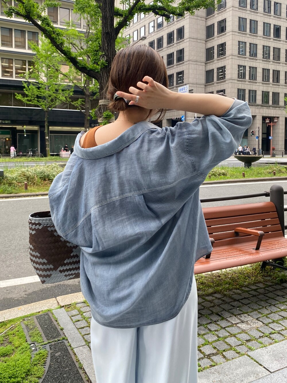 ブルー系のシャツ/ブラウス、ブラウン系のタンクトップ、ブルー系のスラックスを着用したレディースの春コーディネートの3枚目の写真