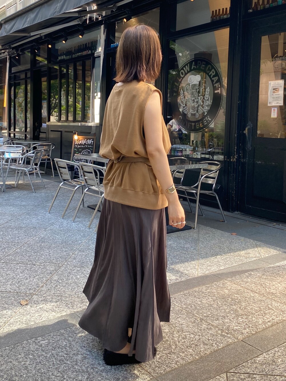 イエロー系のスウェット、グレー系のスカート、ブラウン系のテーラードジャケットを着用したレディースの夏コーディネートの10枚目の写真