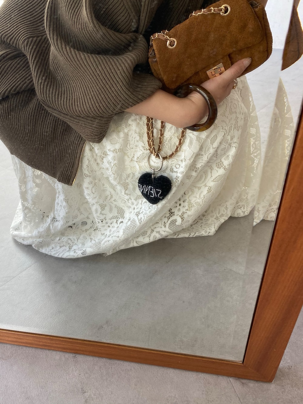 ブラウン系のニット/セーター、イエロー系のショルダーバッグ、ホワイト系のスカートを着用したレディースの秋コーディネートの8枚目の写真