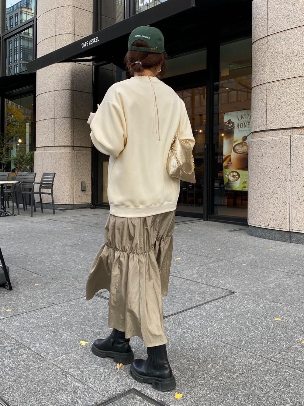 ホワイト系のダウンジャケット/コート、ゴールド系のショルダーバッグ、ホワイト系のワンピースを着用したレディースの冬コーディネートの10枚目の写真