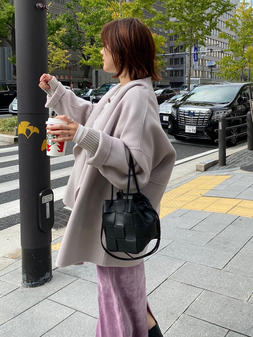 ベージュ系のその他アウター、グレー系のカーディガン/ボレロ、パープル系のスカートを着用したレディースの秋コーディネートの3枚目の写真