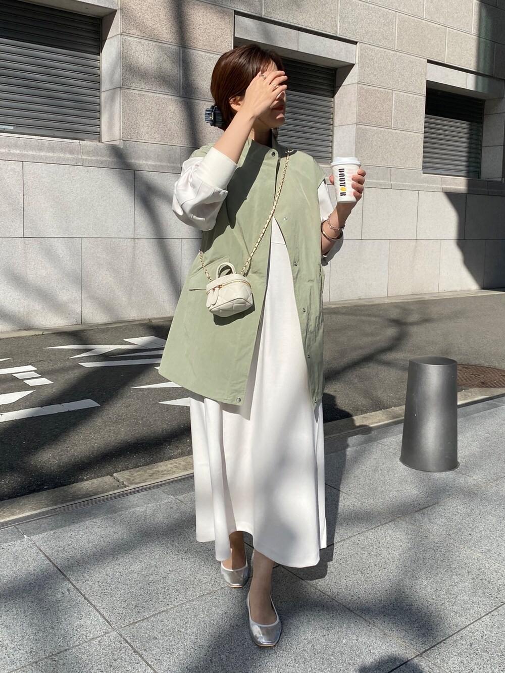 ホワイト系のワンピース、ブラック系のショルダーバッグを着用したレディースの春コーディネートの5枚目の写真