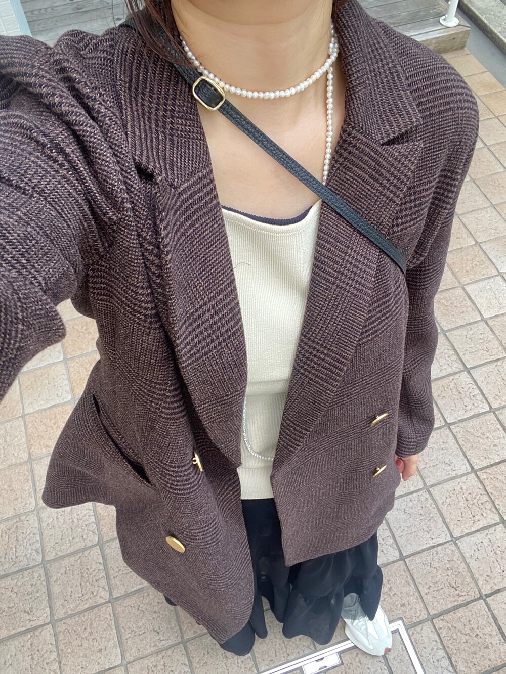 ブラウン系のテーラードジャケット、ブラック系のスカート、ブラック系のショルダーバッグを着用したレディースの秋コーディネートの3枚目の写真