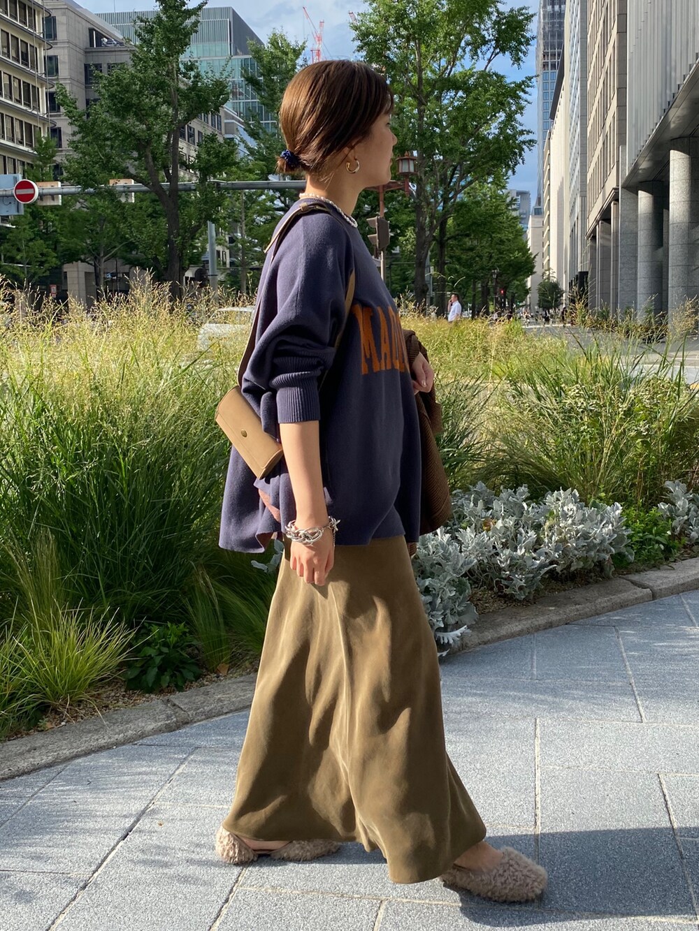 ブルー系のニット/セーター、グリーン系のスカート、ブラウン系のテーラードジャケットを着用したレディースの秋コーディネートの3枚目の写真