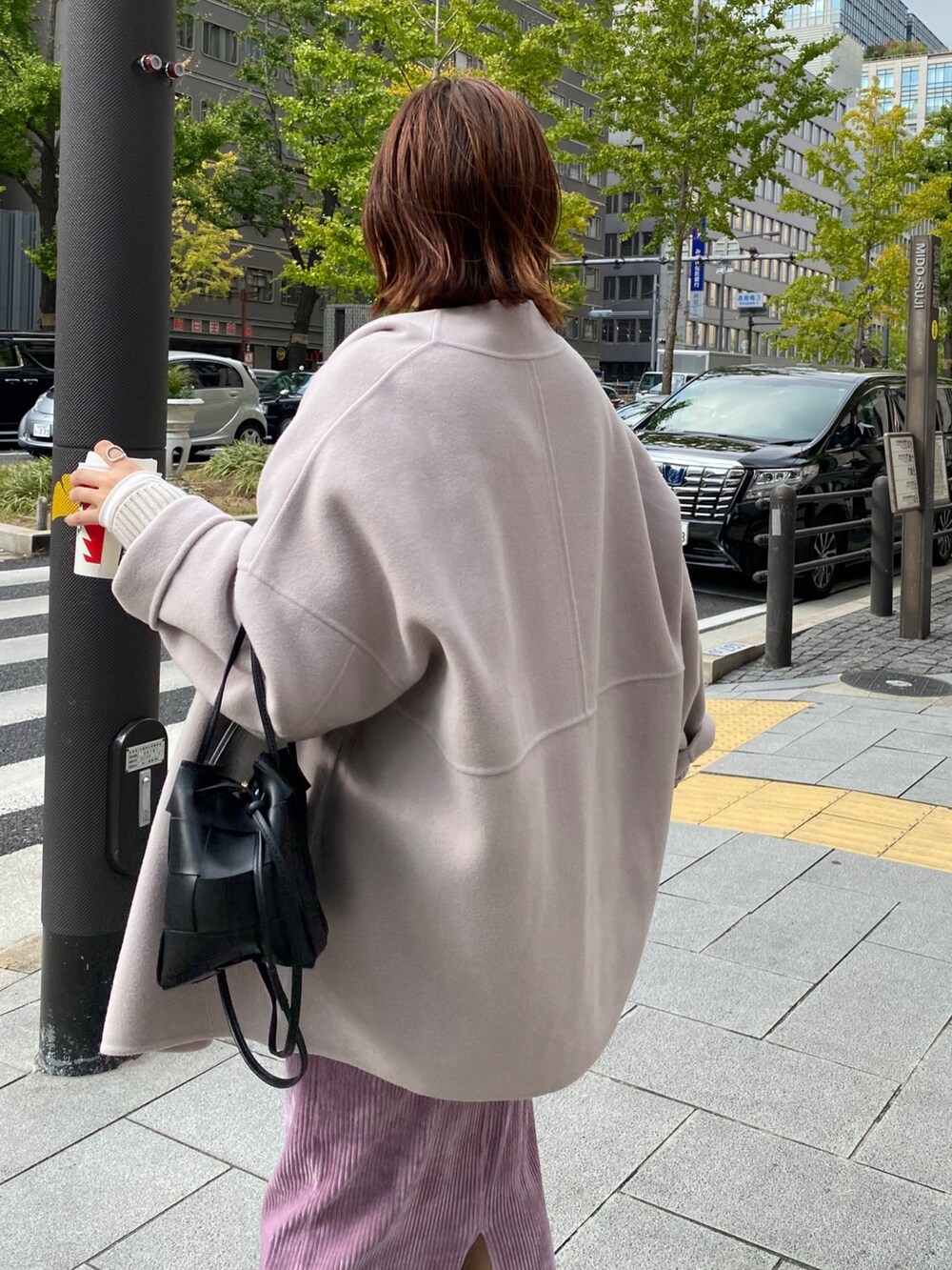 ベージュ系のその他アウター、グレー系のカーディガン/ボレロ、パープル系のスカートを着用したレディースの秋コーディネートの5枚目の写真