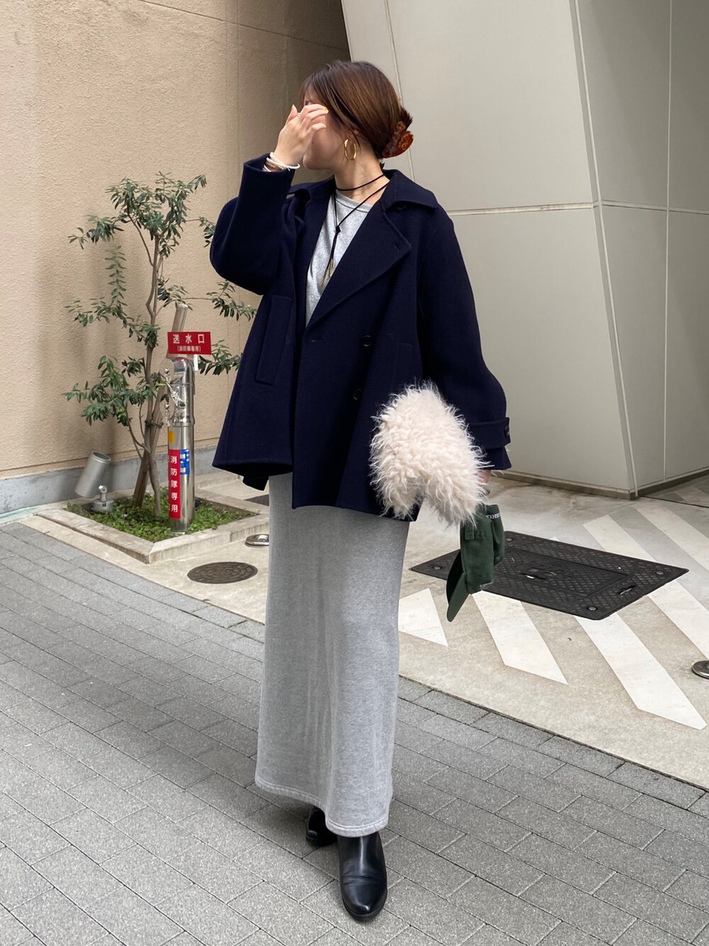 シルバー系のスウェット、シルバー系のスカート、ブラック系のブーツを着用したレディースの秋コーディネートの3枚目の写真