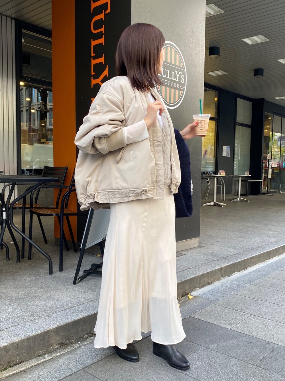ベージュ系のMA-1、ベージュ系のベスト、ホワイト系のスカートを着用したレディースの秋コーディネートの10枚目の写真