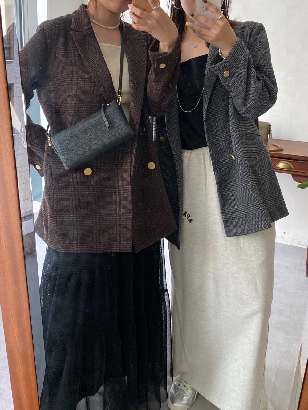 ブラウン系のテーラードジャケット、ブラック系のスカート、ブラック系のショルダーバッグを着用したレディースの秋コーディネートの4枚目の写真