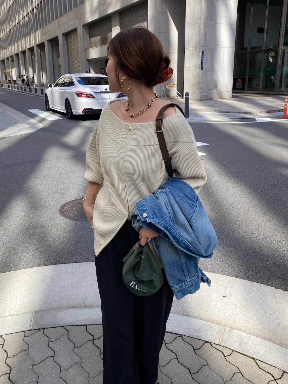 ベージュ系のニット/セーター、ブラック系のパンプス、ブルー系のその他アウターを着用したレディースの秋コーディネートの2枚目の写真