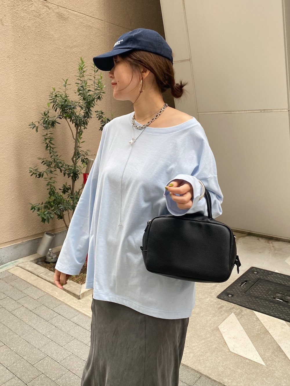 ブルー系のTシャツ/カットソー、ブラック系のスカート、ブラック系のショルダーバッグを着用したレディースの春コーディネートの4枚目の写真
