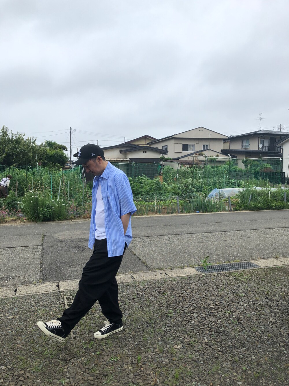 ブルー系のシャツ/ブラウス、ブラック系のチノパンツを着用したメンズの夏コーディネートの2枚目の写真