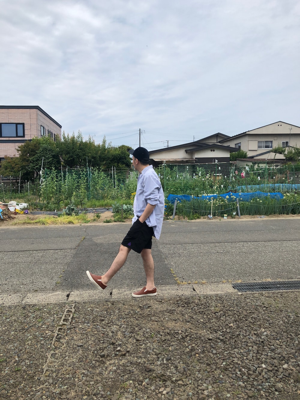 ブルー系のシャツ/ブラウス、オレンジ系のスリッポンを着用したメンズの夏コーディネートの2枚目の写真