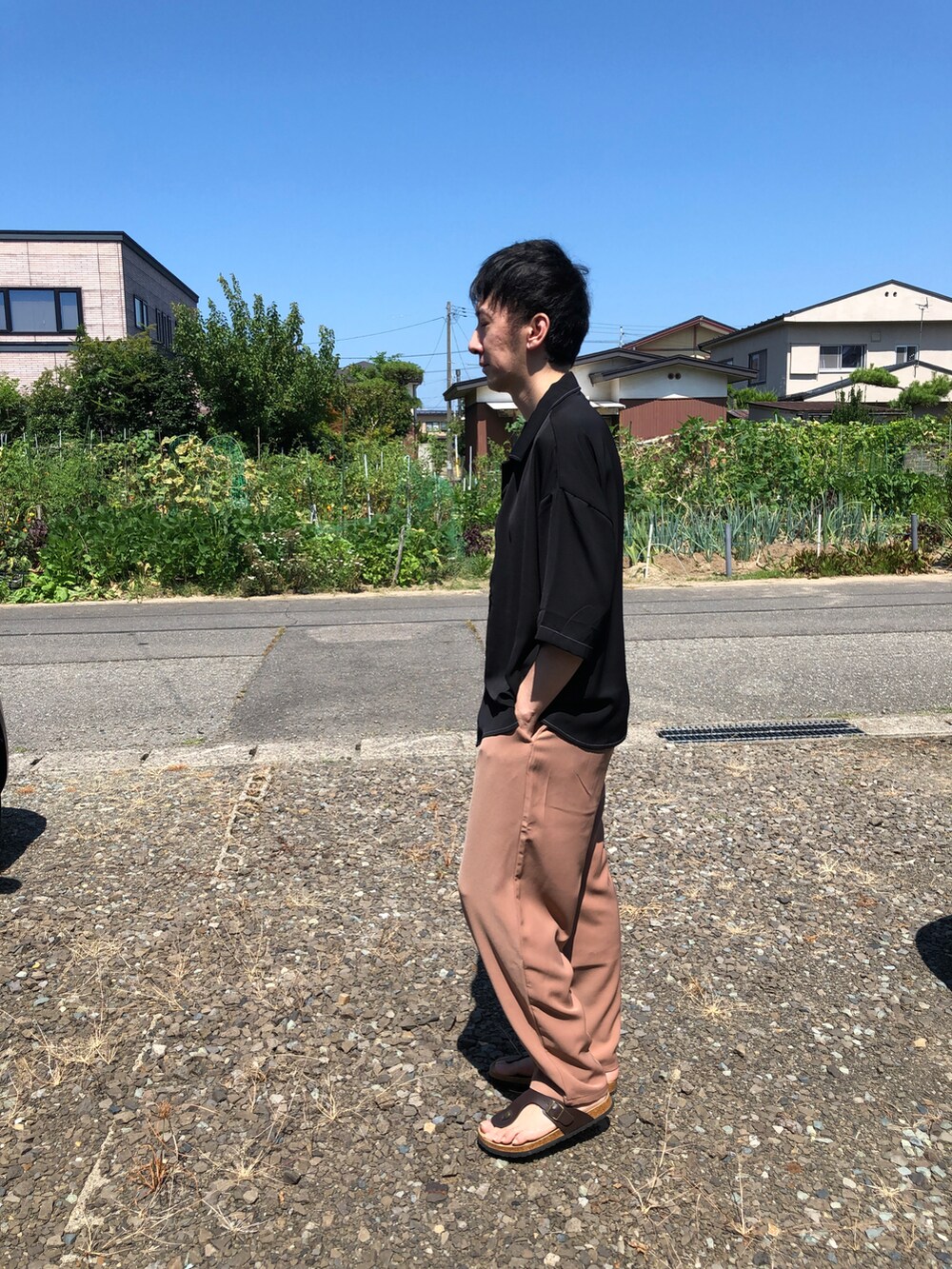 ブラック系のシャツ/ブラウス、ベージュ系のパンツを着用したメンズの夏コーディネートの2枚目の写真