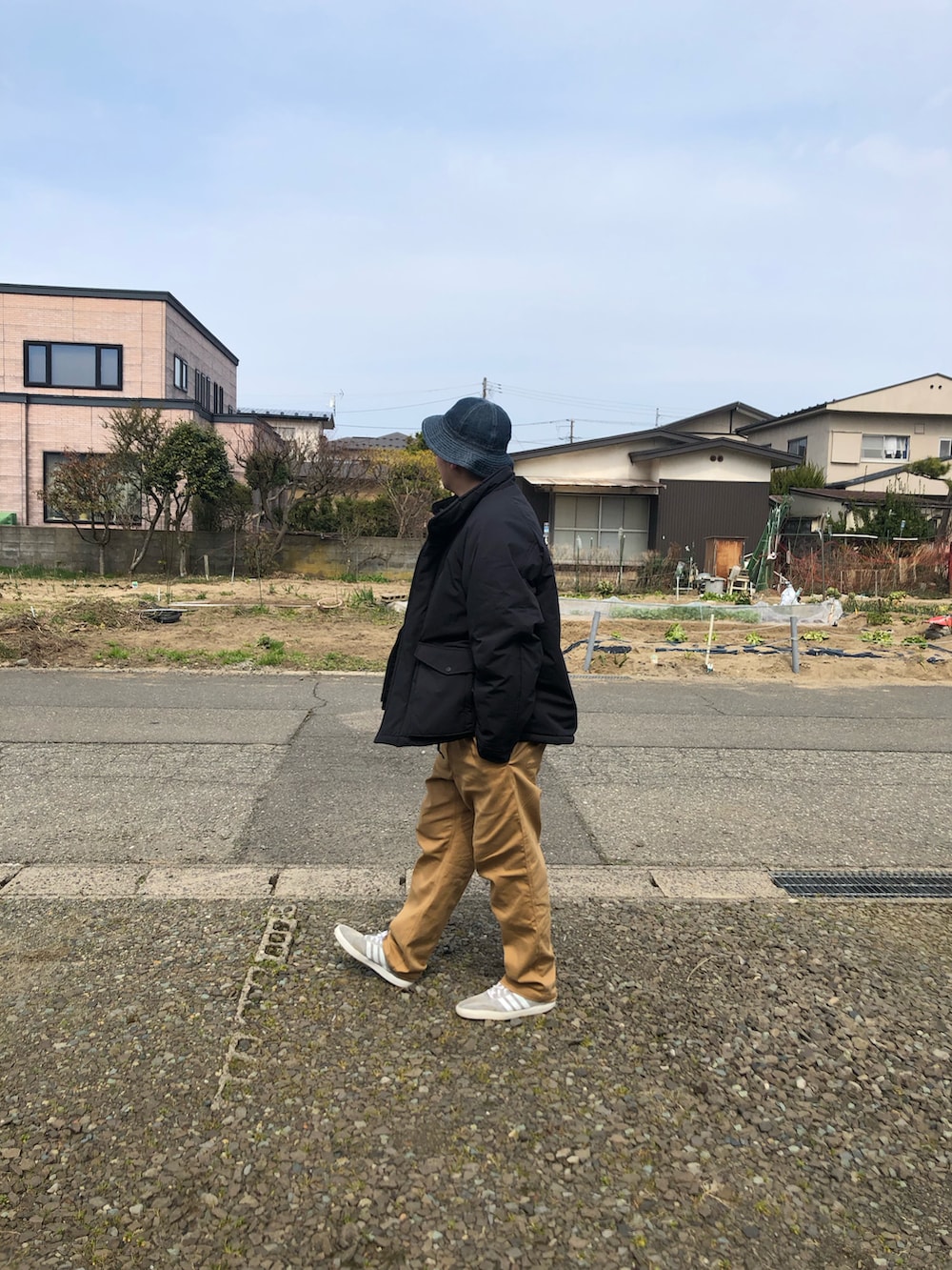 ブラック系のダウンジャケット/コート、ベージュ系のその他パンツを着用したメンズの春コーディネートの3枚目の写真