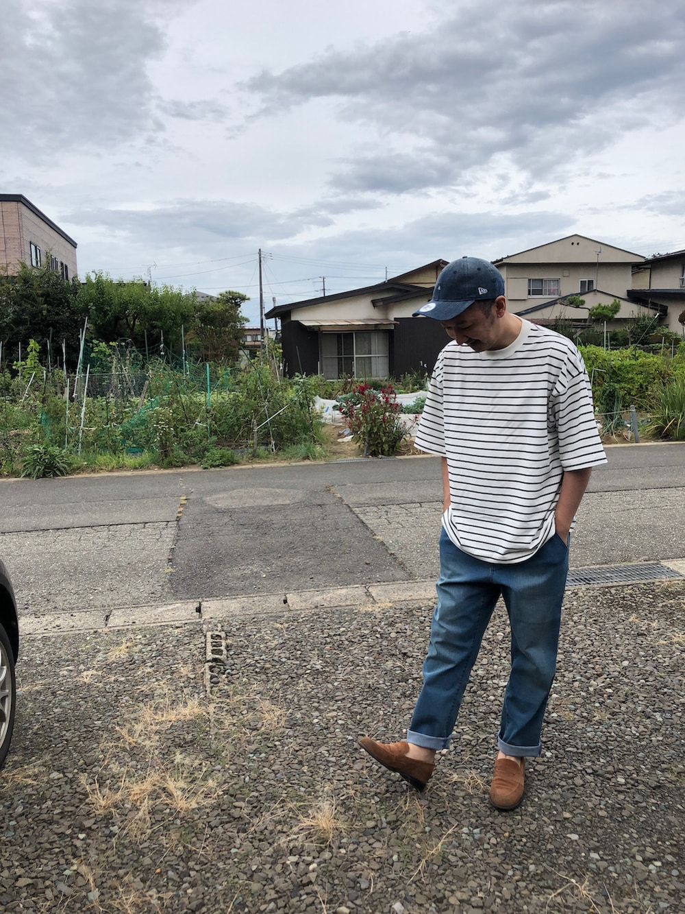 ホワイト系のTシャツ/カットソー、ブルー系のデニムパンツ、ベージュ系のローファーを着用したメンズの秋コーディネートの2枚目の写真