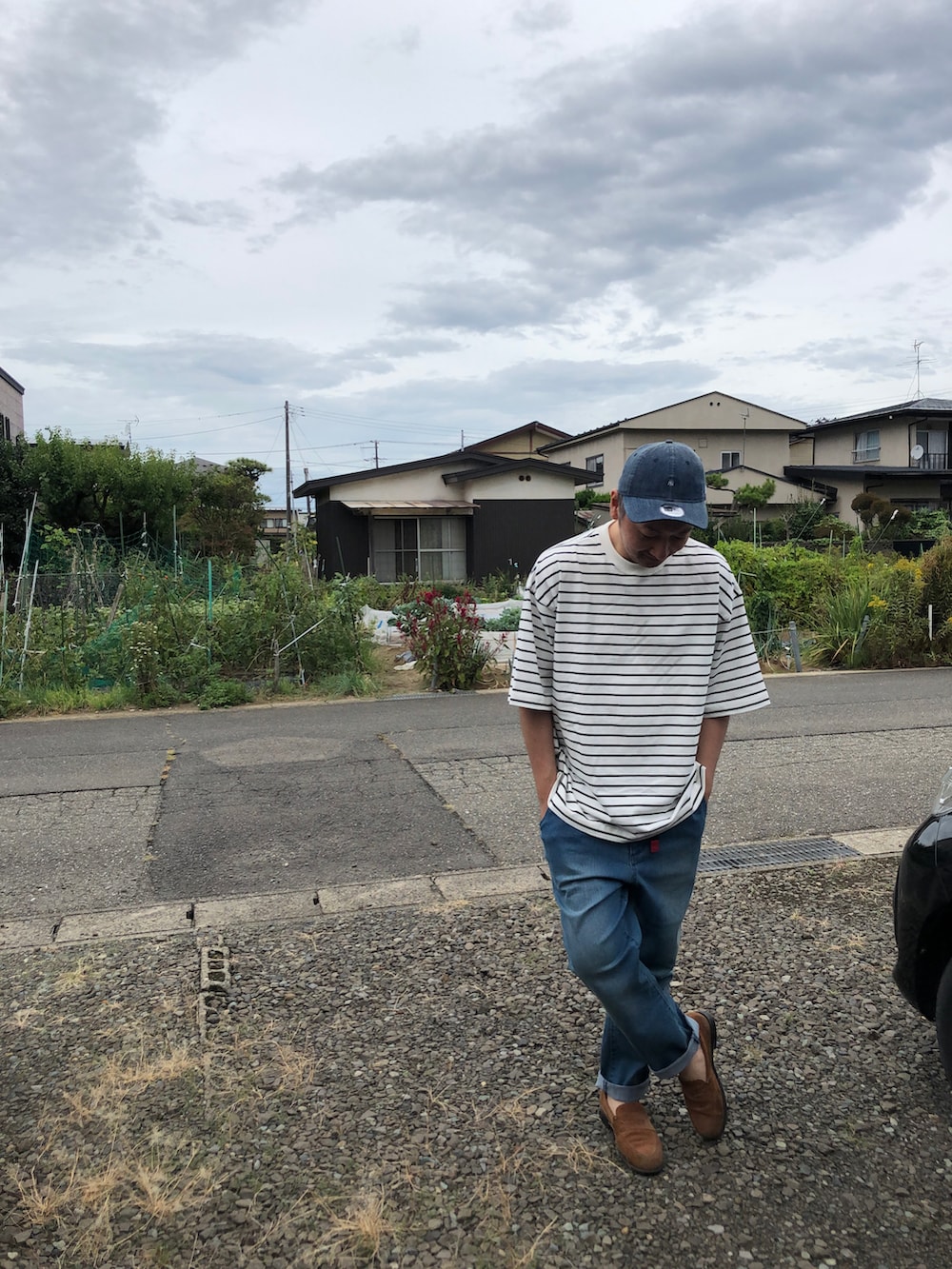 ホワイト系のTシャツ/カットソー、ブルー系のデニムパンツ、ベージュ系のローファーを着用したメンズの秋コーディネートの3枚目の写真