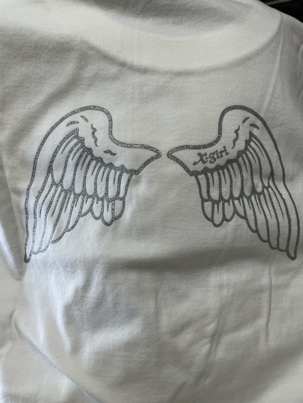 ホワイト系のTシャツ/カットソー、ブラック系のショルダーバッグ、グリーン系のスニーカーを着用したレディースの夏コーディネートの2枚目の写真