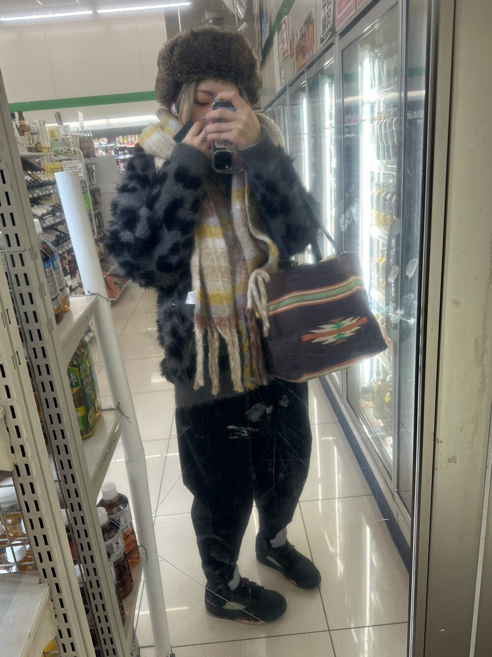 ブラック系のスニーカー、ホワイト系のニットキャップ/ビーニーを着用したレディースの冬コーディネートの5枚目の写真