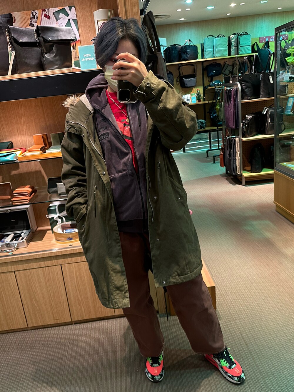 グリーン系のモッズコート、ブラウン系のパンツを着用したレディースの冬コーディネートの3枚目の写真