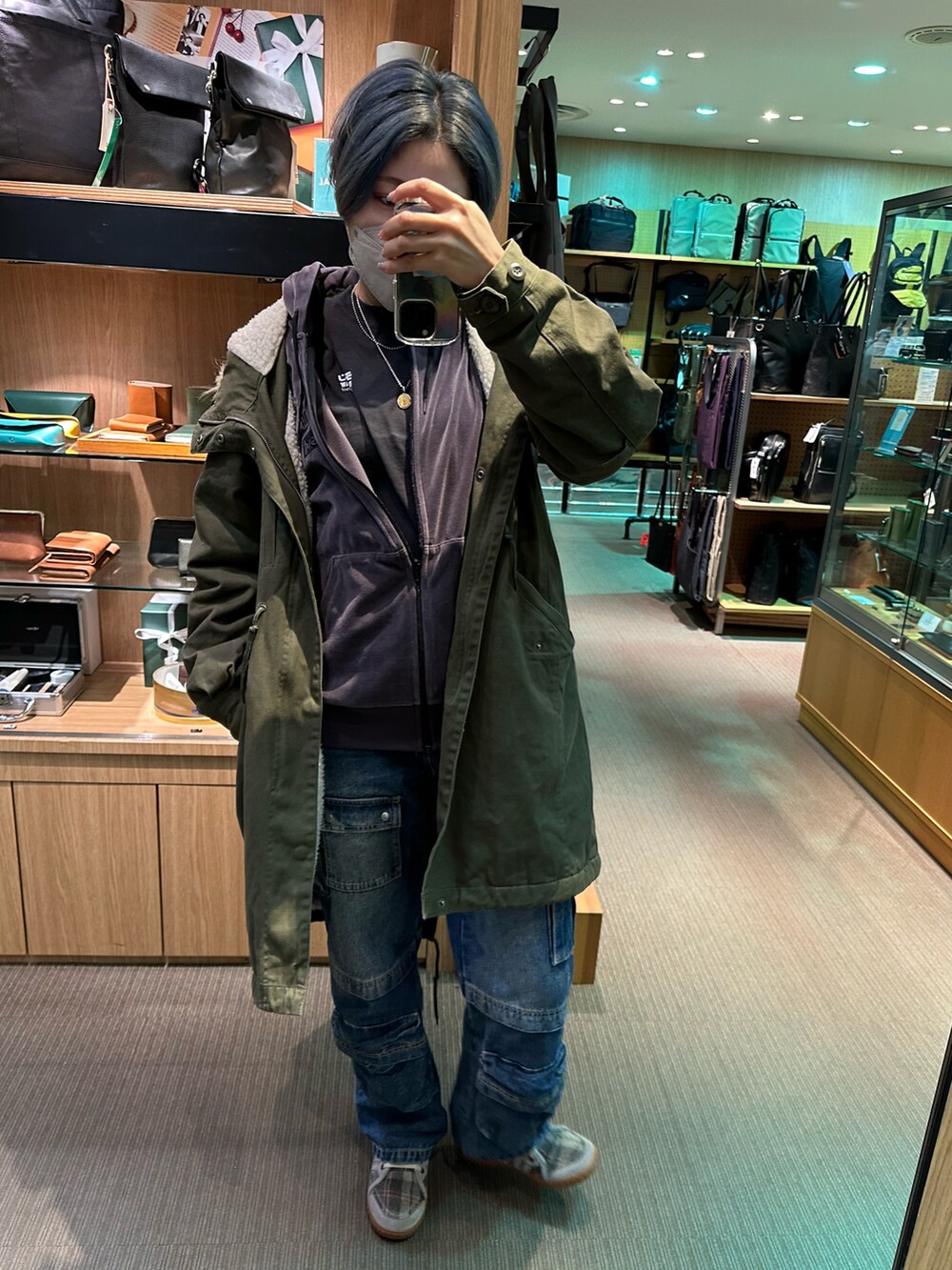 グリーン系のモッズコート、ブラウン系のパンツを着用したレディースの冬コーディネートの4枚目の写真