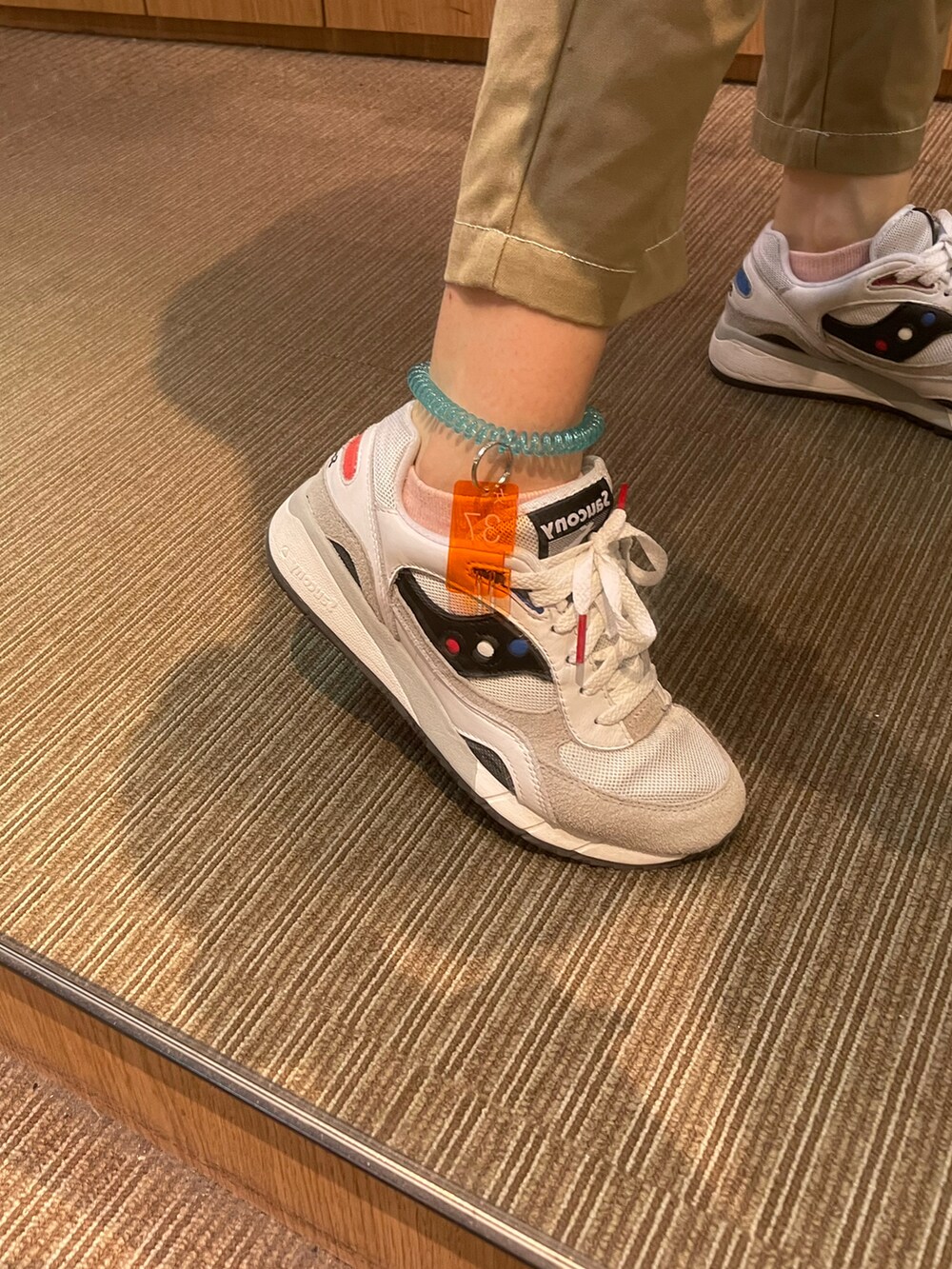 ブラック系のTシャツ/カットソー、ベージュ系のチノパンツ、シルバー系のバッグを着用したレディースの夏コーディネートの3枚目の写真