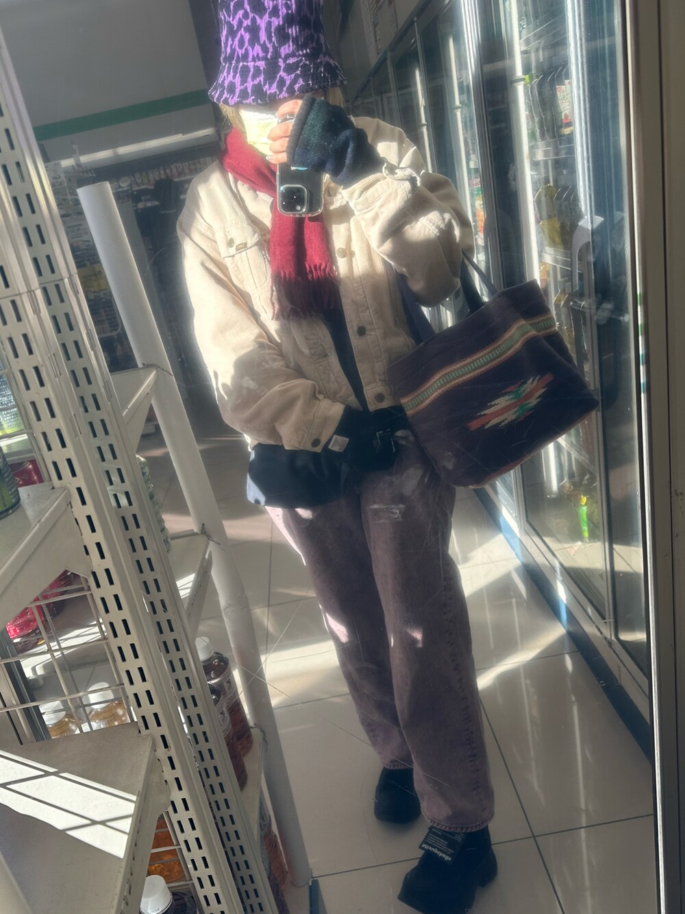 ブラック系のデニムパンツ、ブラック系のハットを着用したレディースの冬コーディネートの2枚目の写真