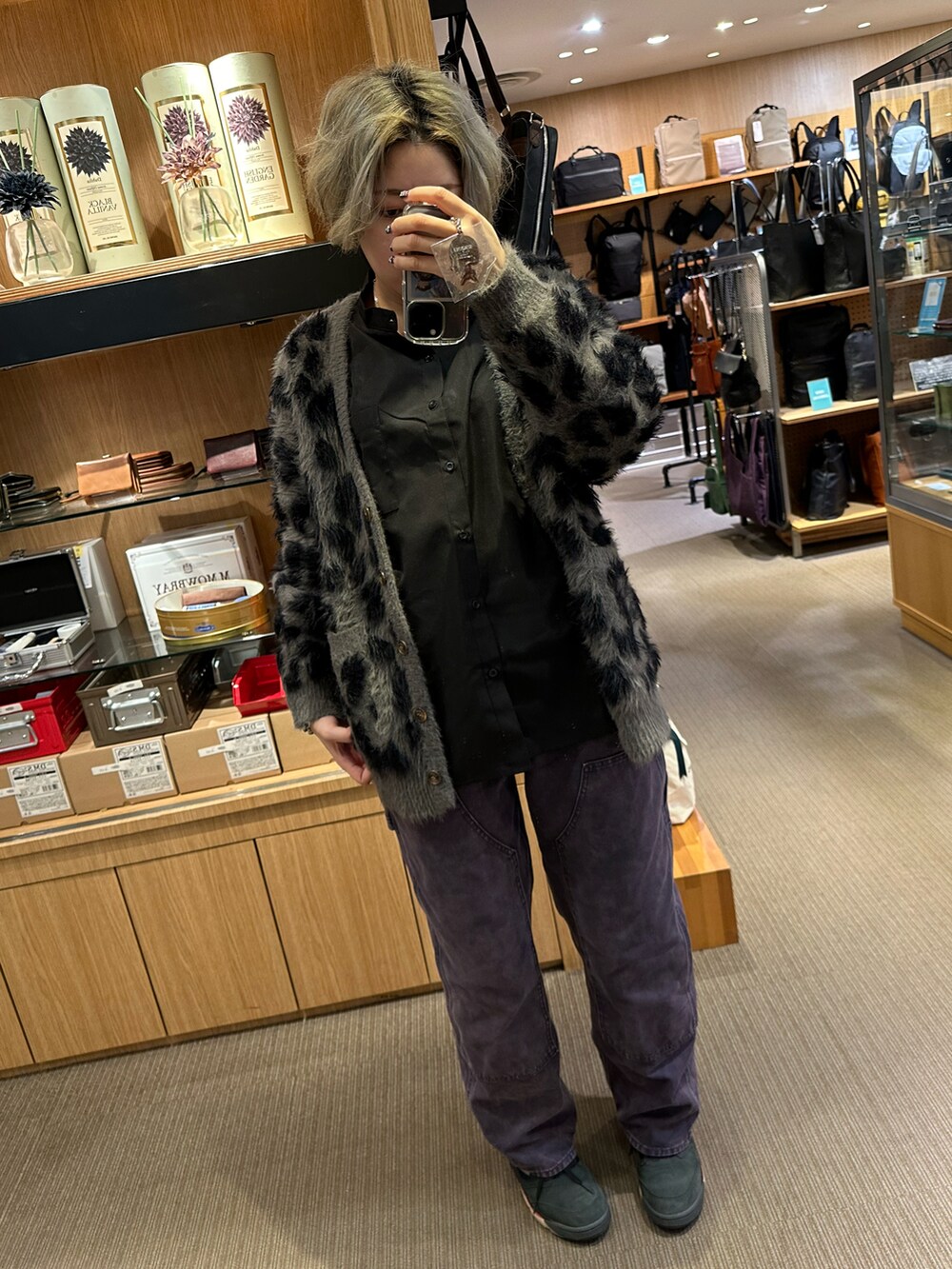 ブラウン系のパーカー、グリーン系のパンツ、ブラック系のブーツを着用したレディースの春コーディネートの4枚目の写真