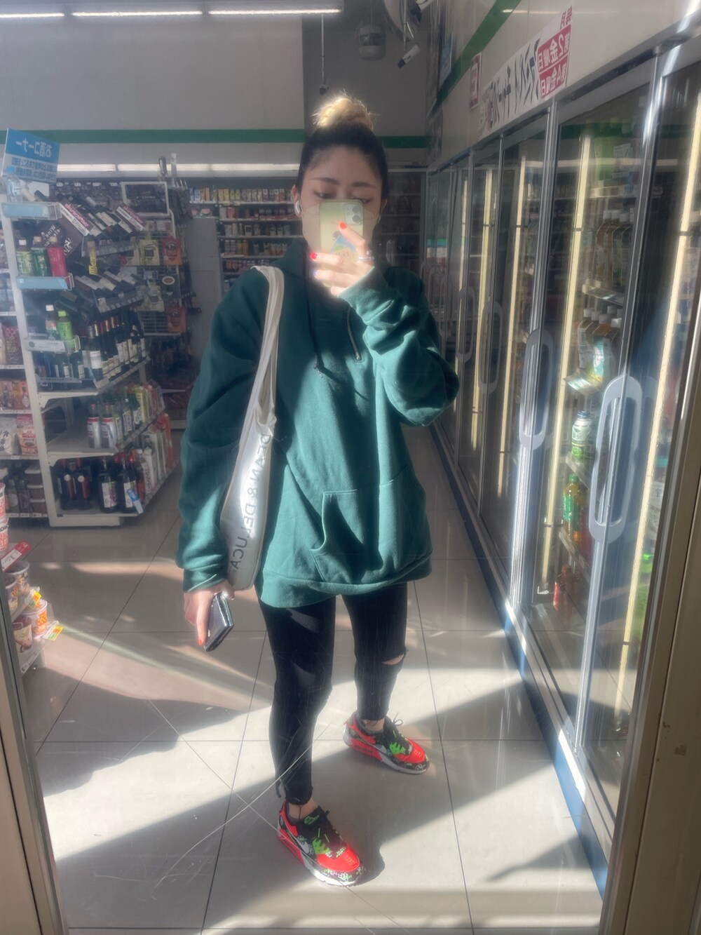 ブラック系のショルダーバッグ、ピンク系のスニーカー、グレー系の帽子を着用したレディースの秋コーディネートの4枚目の写真