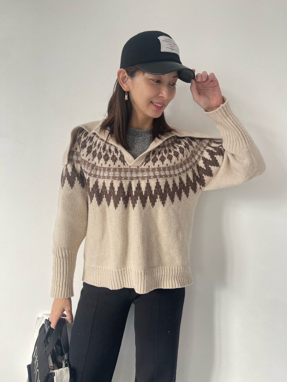 ホワイト系のニット/セーター、ブラック系のその他パンツ、ブラック系のキャップを着用したレディースの冬コーディネートの3枚目の写真