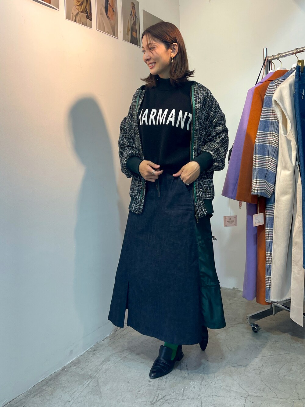 グリーン系のスカート、ブルー系のMA-1、ブラック系のニット/セーターを着用したレディースの春コーディネートの3枚目の写真