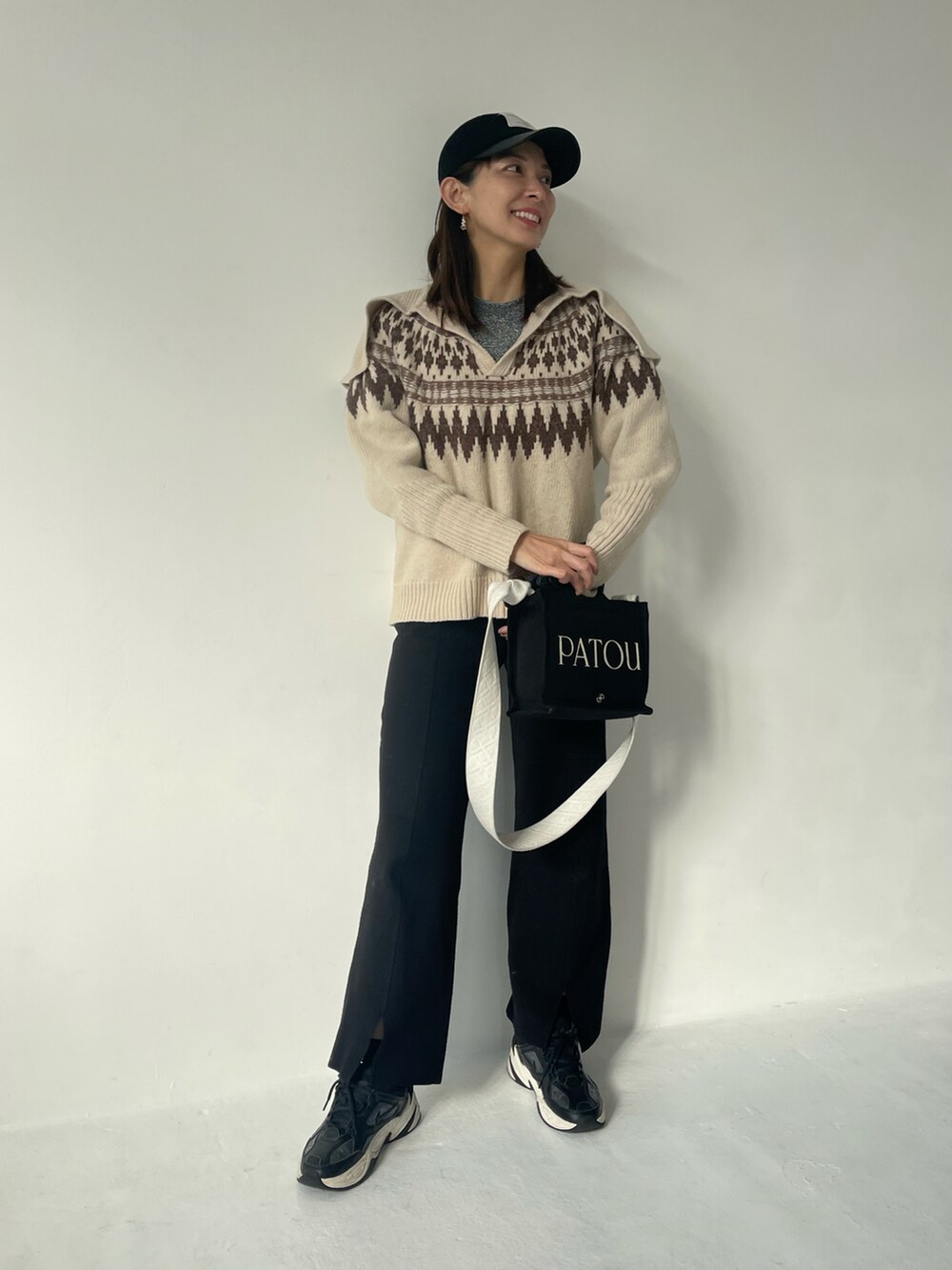 ホワイト系のニット/セーター、ブラック系のその他パンツ、ブラック系のキャップを着用したレディースの冬コーディネートの2枚目の写真