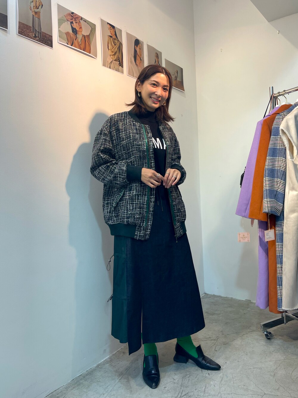 グリーン系のスカート、ブルー系のMA-1、ブラック系のニット/セーターを着用したレディースの春コーディネートの2枚目の写真