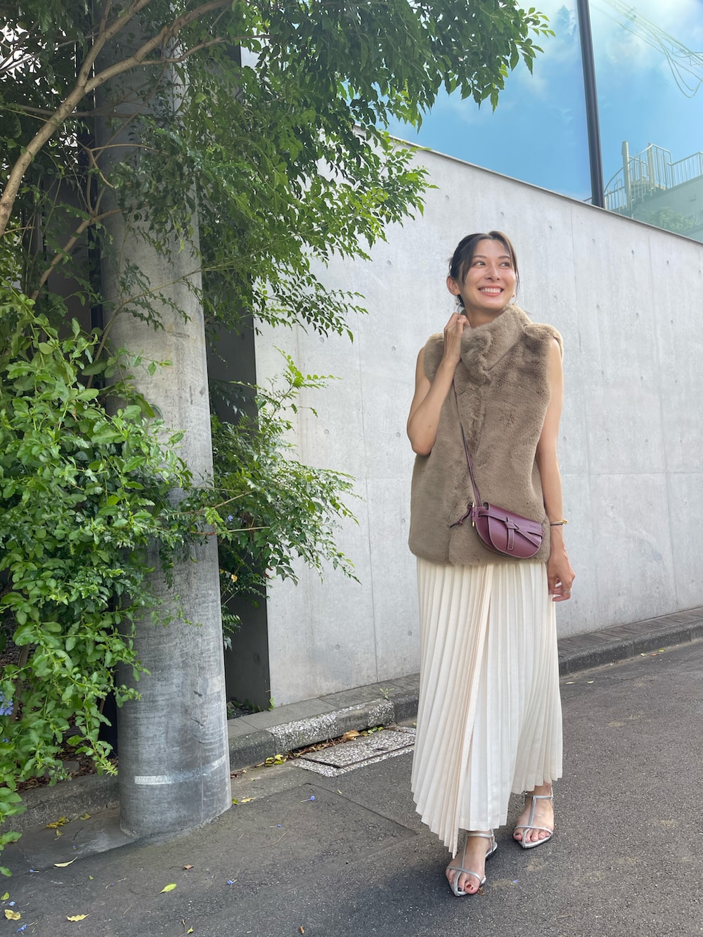 ブラウン系のベスト、ベージュ系のワンピース、シルバー系のサンダルを着用したレディースの夏コーディネートの2枚目の写真