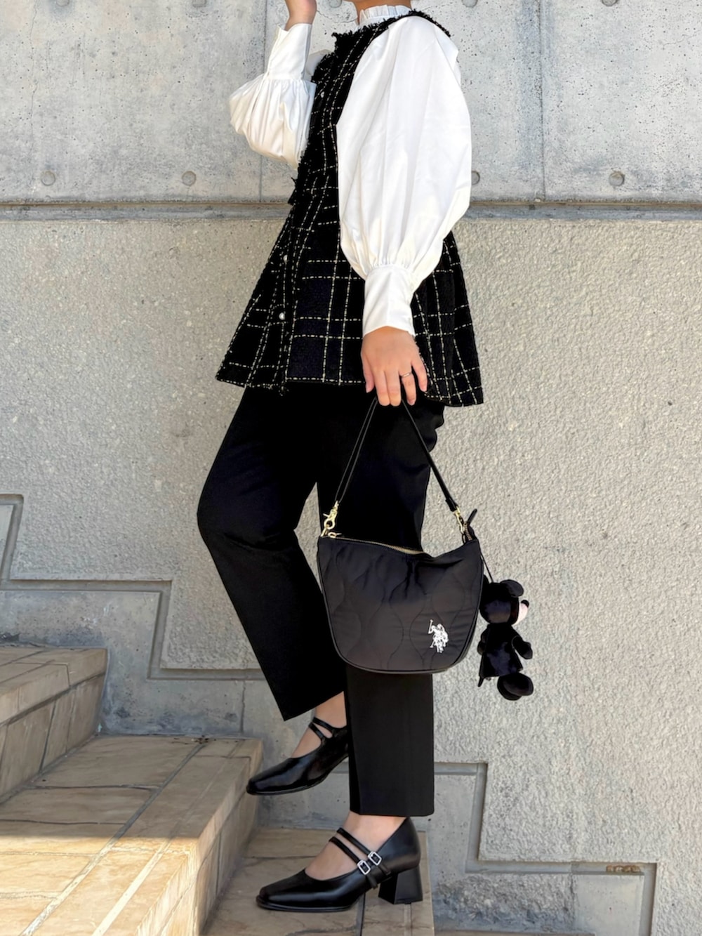 ブラック系のその他パンツ、ブラック系のショルダーバッグ、ホワイト系のシャツ/ブラウスを着用したレディースの冬コーディネートの2枚目の写真