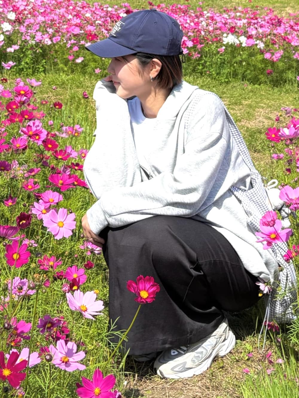 グレー系のパーカー、ブラック系のスカート、グレー系のスニーカーを着用したレディースの冬コーディネートの3枚目の写真