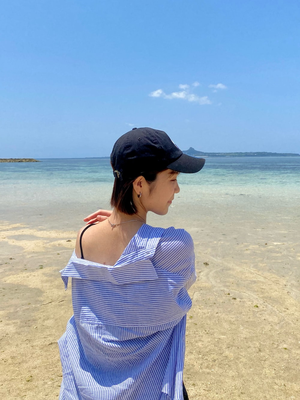 ブラック系のスニーカー、ブラック系のボストンバッグ、ブラック系のワンピースを着用したレディースの春コーディネートの2枚目の写真