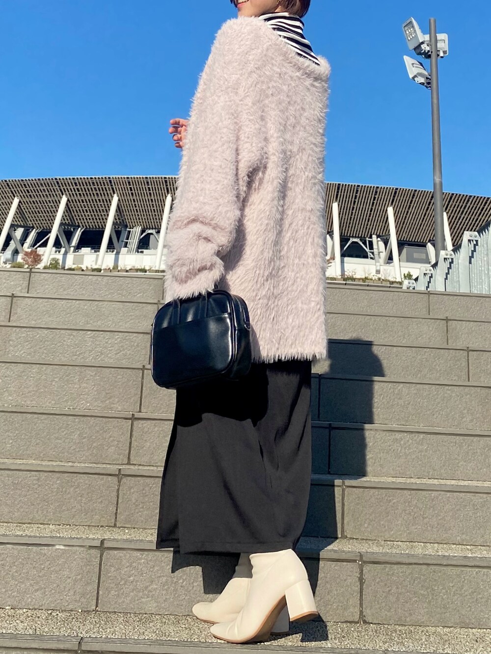 ブラック系のワンピース、ピンク系のカーディガン/ボレロ、ブラック系のTシャツ/カットソーを着用したレディースの冬コーディネートの3枚目の写真