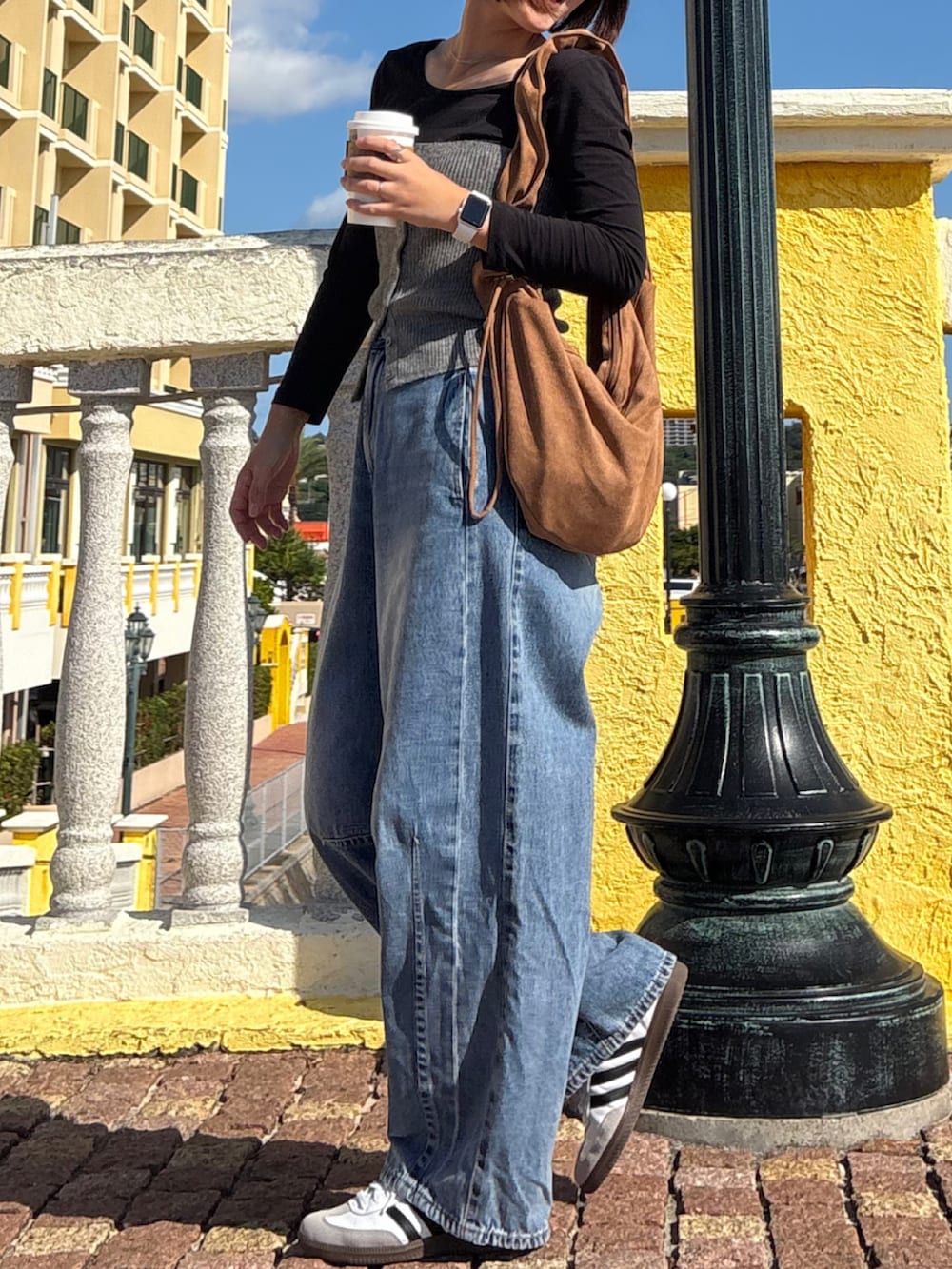 ブルー系のデニムパンツ、ホワイト系のスニーカー、シルバー系のネックレスを着用したレディースの冬コーディネートの2枚目の写真