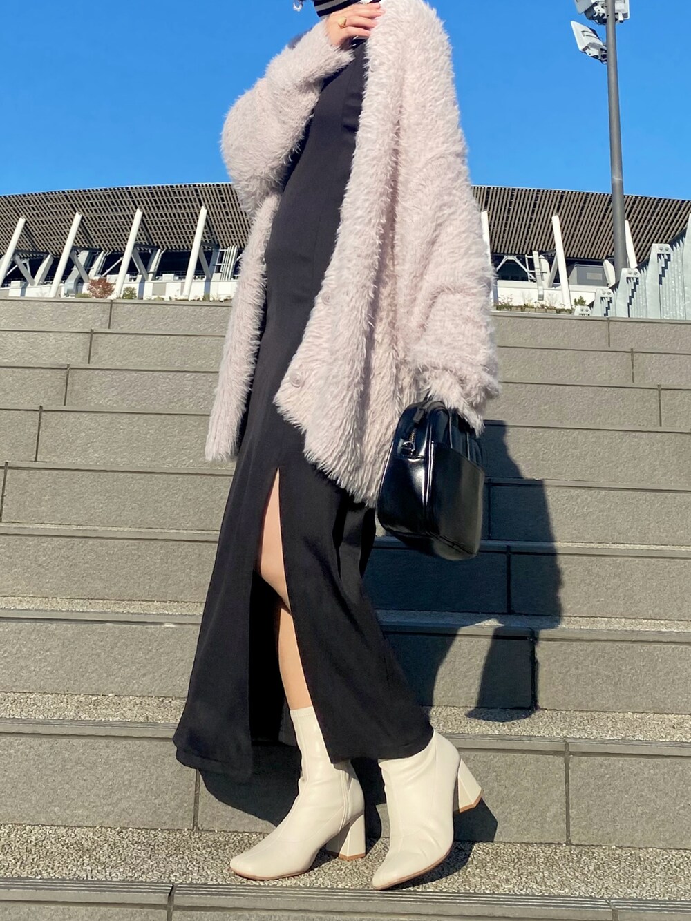 ブラック系のワンピース、ピンク系のカーディガン/ボレロ、ブラック系のTシャツ/カットソーを着用したレディースの冬コーディネートの2枚目の写真