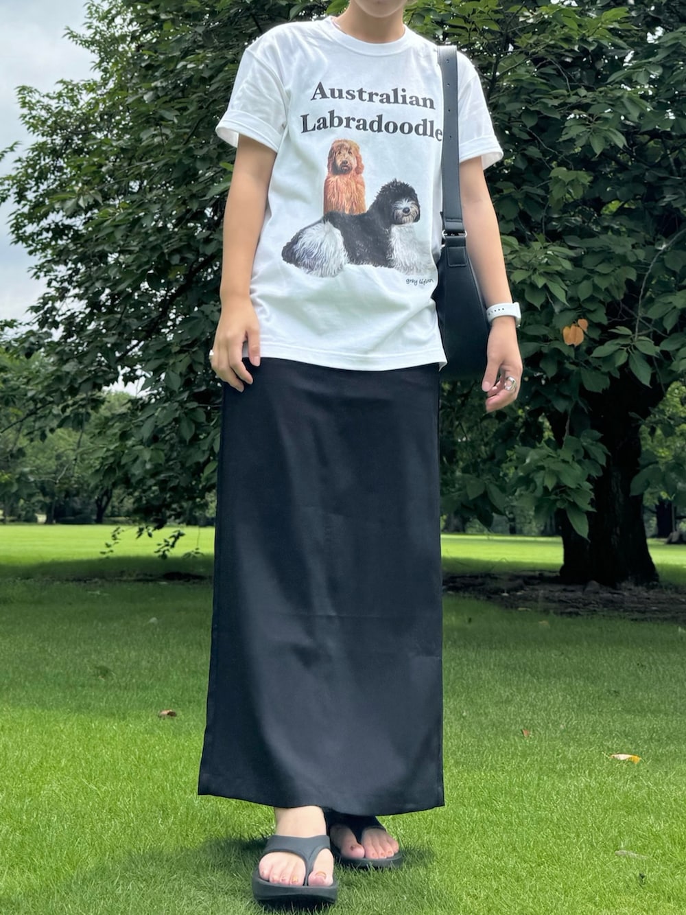 ブラック系のサンダル、ブラック系のスカート、シルバー系のネックレスを着用したレディースの夏コーディネートの2枚目の写真