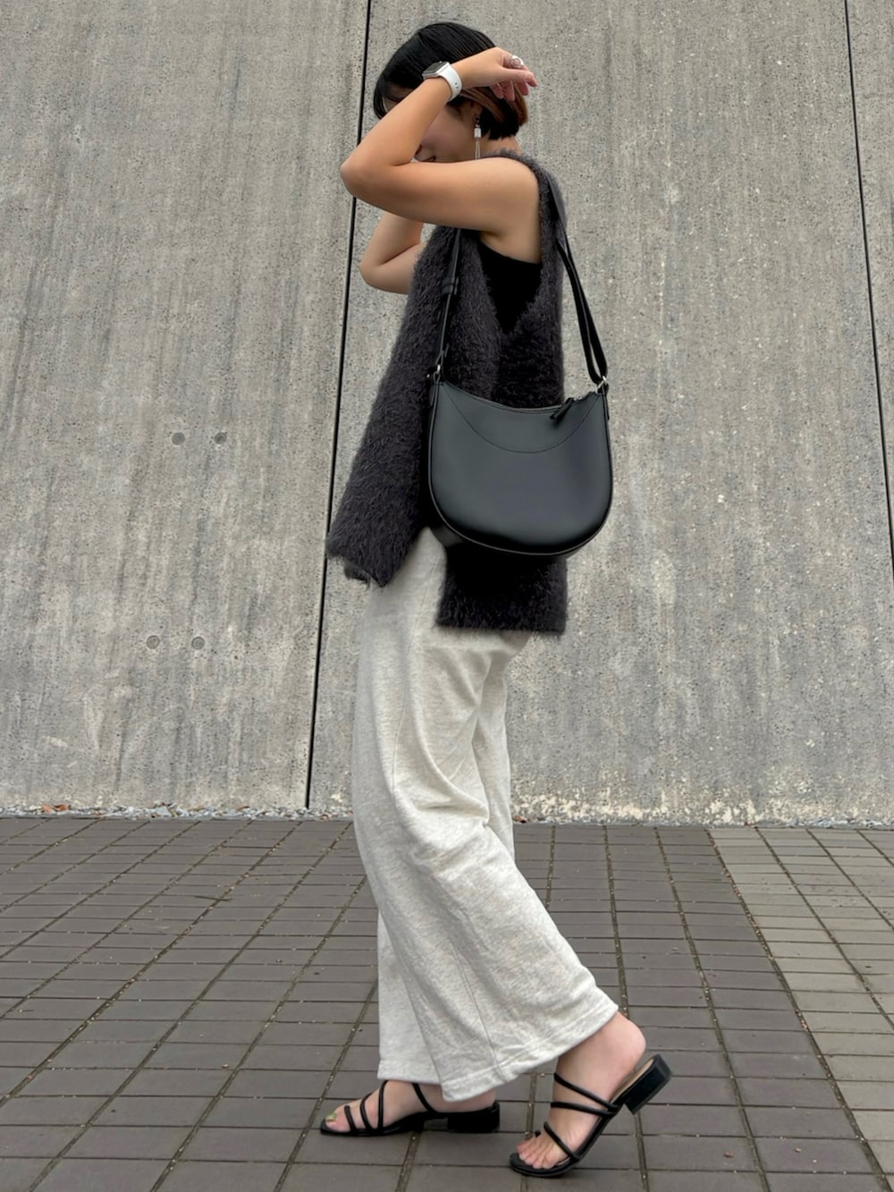 ベージュ系のスウェットパンツ、グレー系のベスト、ブラック系のキャミソールを着用したレディースの秋コーディネートの2枚目の写真